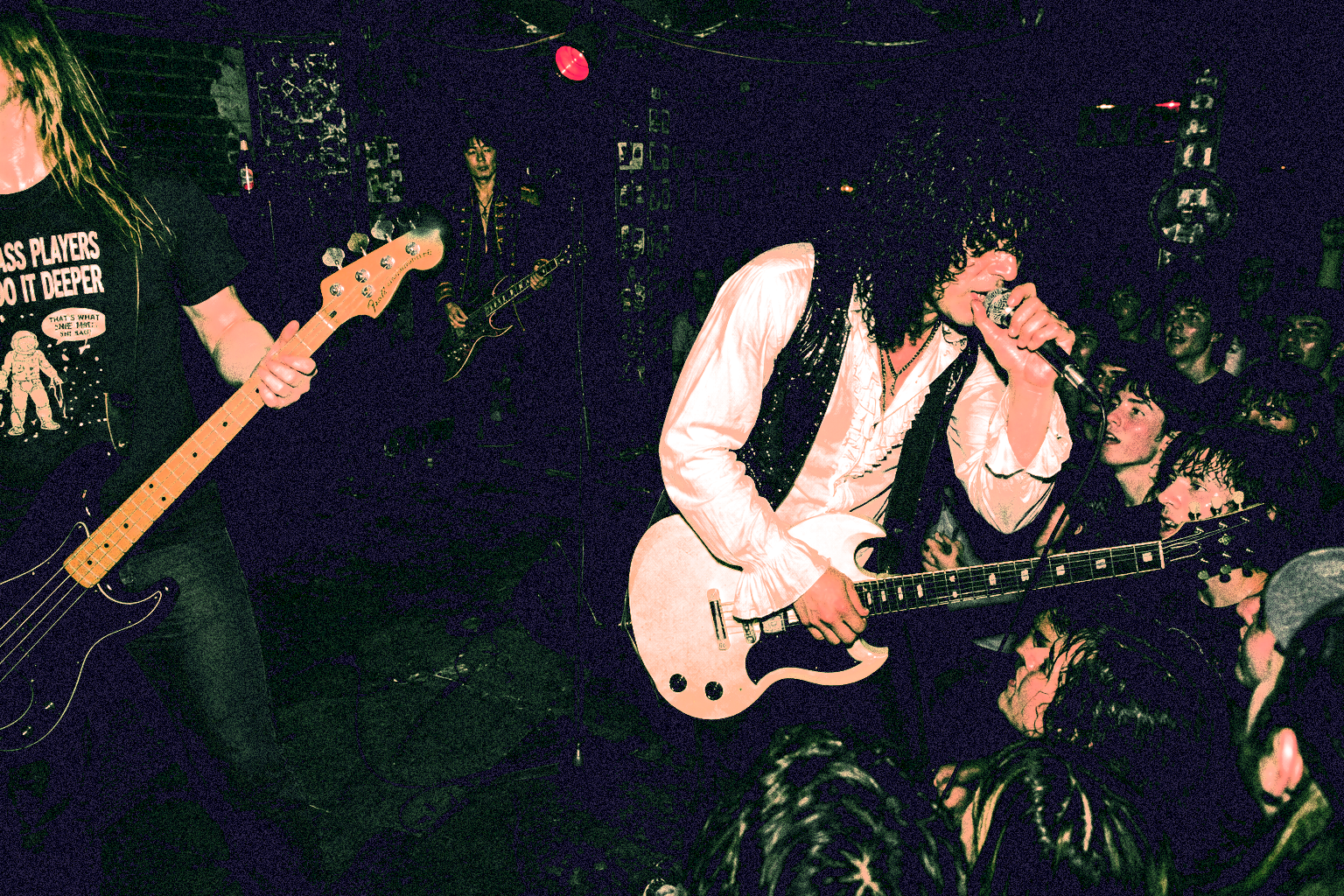 Brian Damage singing at the edge of a packed club stage
